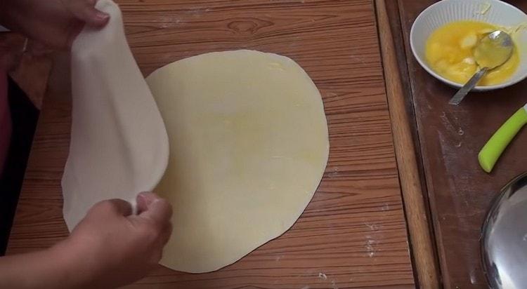 Fetten Sie jeden Teigkreis mit geschmolzener Butter ein und stapeln Sie sie übereinander.