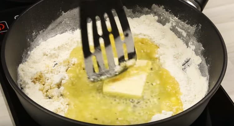 Fügen Sie dem Mehl ein Stück Butter hinzu und mischen Sie.