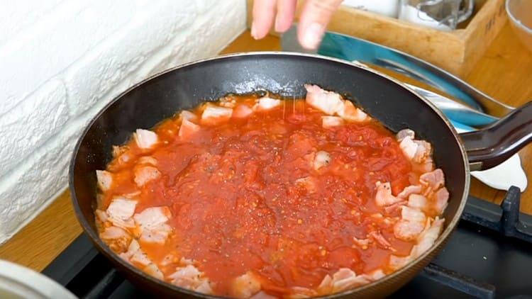 Омесете доматите с шпатула, добавете сол, черен пипер.