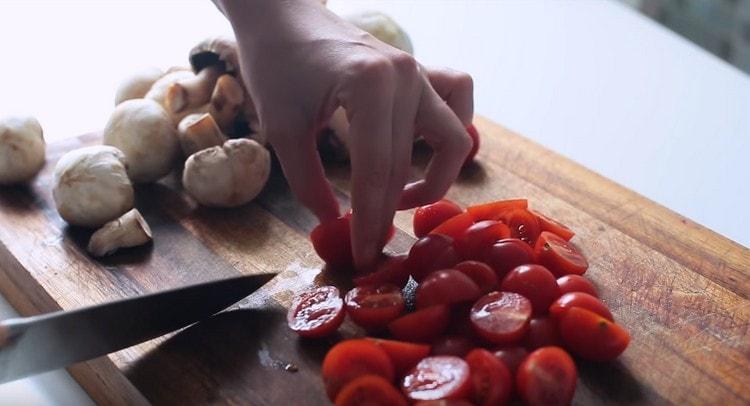 Нарежете чери доматите.