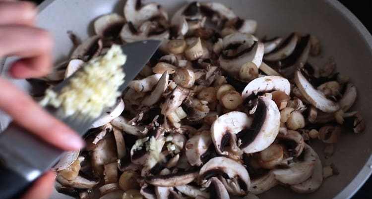 Aggiungi l'aglio ai funghi.