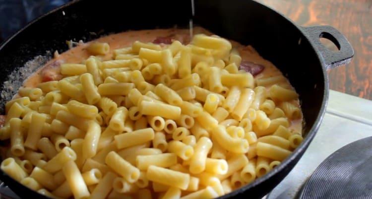 Разстиламе сварената паста в соса.