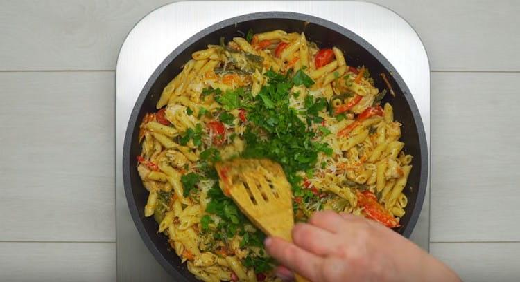 Levitä pastaa pannuun, lisää tomaatit ja hienonnettu vihreät.