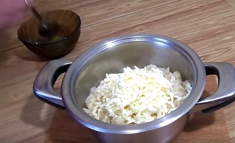Idagdag ang gadgad na pinroseso na keso at ihalo ang pasta.
