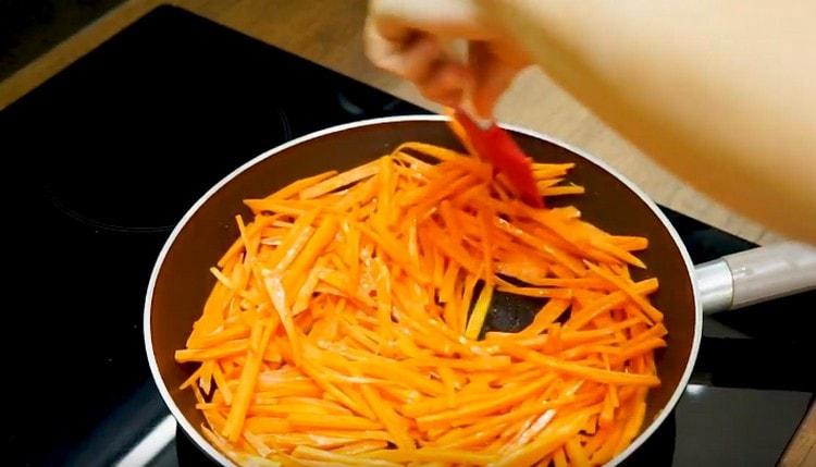 Κατ 'αρχάς, τηγανίζουμε σε μια κατσαρόλα, απλώνουμε τα καρότα.