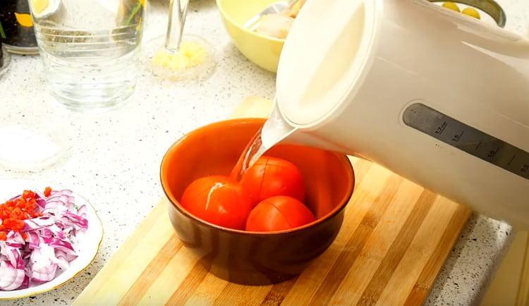 Kaada kiehuvaa vettä tomaattien päälle ja kuori ne.