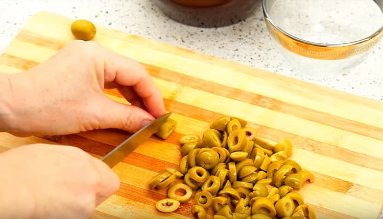 Tagliamo le olive snocciolate in anelli.