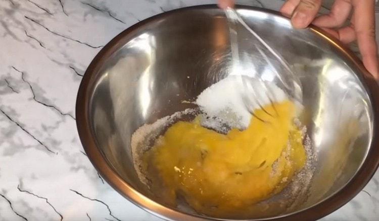 Con una frusta, strofina le uova con lo zucchero.