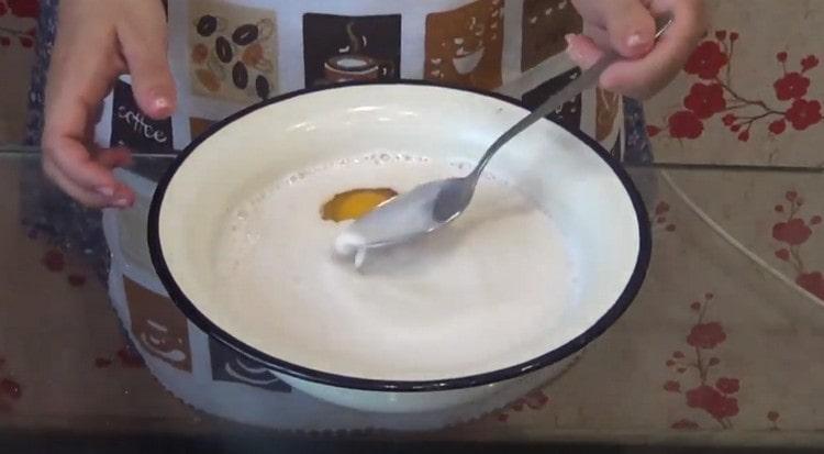 Вкарайте яйце до сместа от мляко и мая.