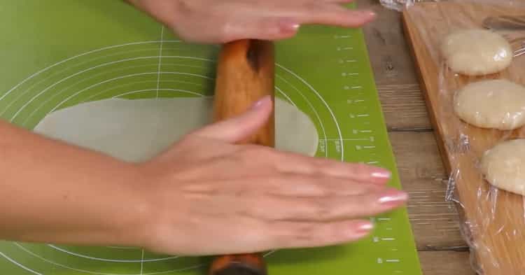 Den Teig ausrollen, um Blätterteigkuchen mit Äpfeln zuzubereiten