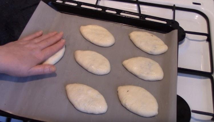 Laita piirakat pergamentilla peitetylle leivonnaiselle ja paina kevyesti alaspäin.