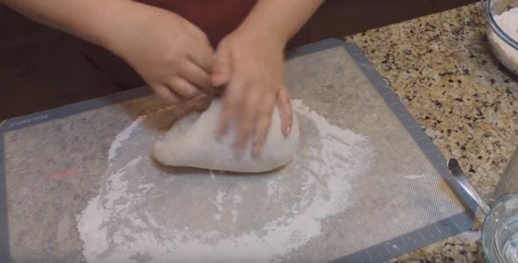 Impastare la pasta con le mani, aggiungendo farina.