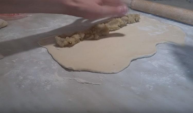 Покрай тестото от едната страна разпределете картофения пълнеж.
