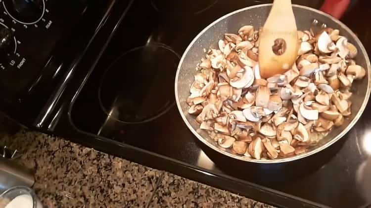 Braten Sie die Pilze an, um Pasteten mit Kartoffeln und Pilzen zuzubereiten