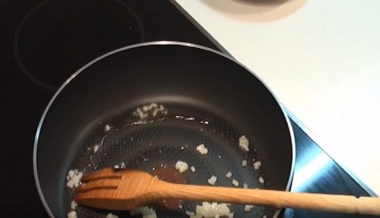 Friggere metà della cipolla tritata in una padella.
