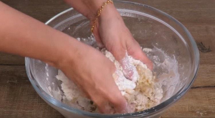 Ръцете смилате брашно с растително масло.