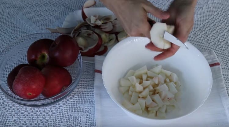 Για να προετοιμάσετε το γέμισμα, ξεφλουδίστε και κόψτε τα μήλα σε κομμάτια.