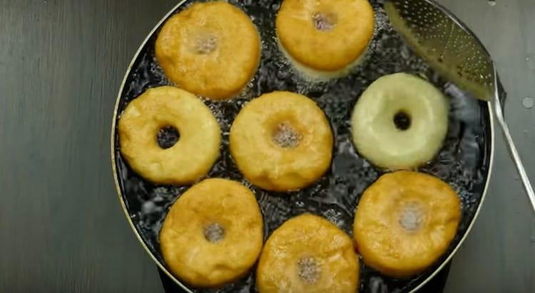 Die Donuts mit Hefe in kochendem Pflanzenöl anbraten.