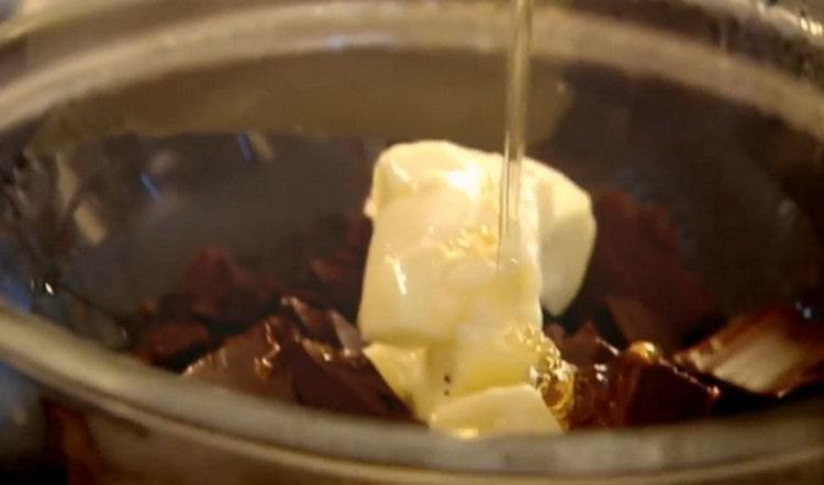Wir ertrinken Schokolade in einem Wasserbad, fügen Butter und Honig hinzu.