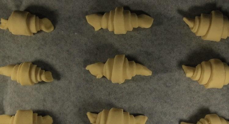 Ipinakalat namin ang mga croissants sa isang baking sheet na natatakpan ng pergamino.