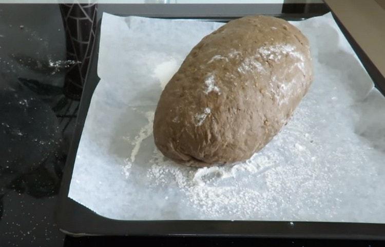Βάλτε το σχηματισμένο ψωμί σε ένα φύλλο ψησίματος που καλύπτεται από περγαμηνή και ψεκάζεται ελαφρά με αλεύρι.
