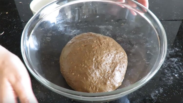 Ilagay ang kneaded dough sa isang mangkok na greased na may langis ng gulay at takpan na may cling film.