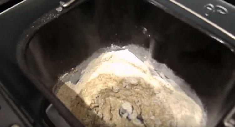 В кофата на машината за хляб разпределяме кваса, добавяме малко ръжено брашно и вода.