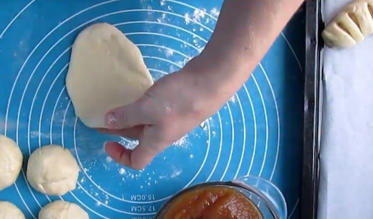 Rotolare le palline di pasta con il mattarello in torte piatte oblunghe.