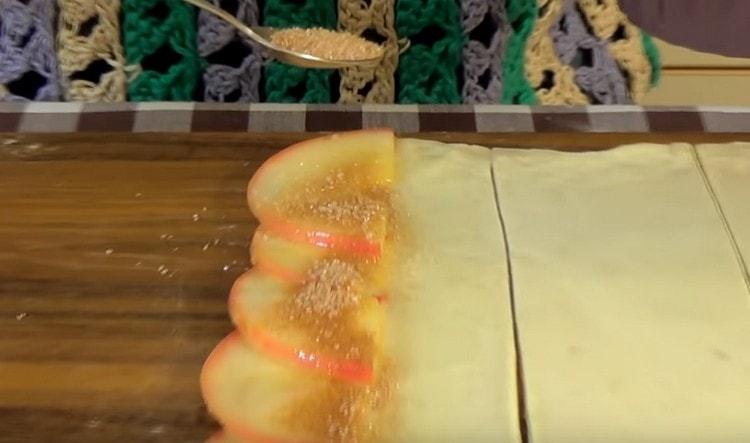 След като намажете ябълките с олио, поръсете ги със захар и канела.