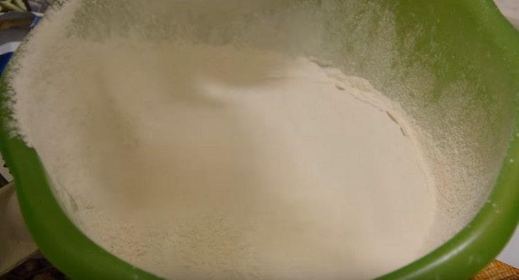 Setacciare la farina nella massa di lievito di latte.