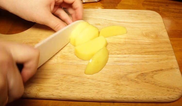 Oloupejte brambory a nakrájejte je na plátky.