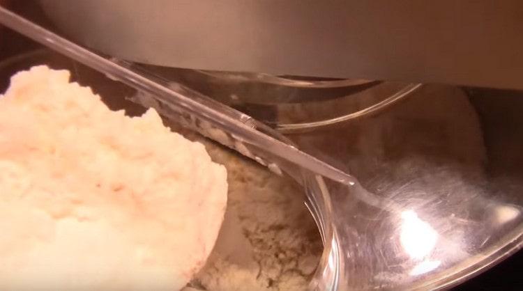 Bekapcsoljuk a kombájnot, és a tésztát keverve fokozatosan vezetünk bele lisztet.