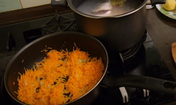 Στρώνουμε τα καρότα με κρεμμύδια μέχρι να μαλακώσουν στο τηγάνι.