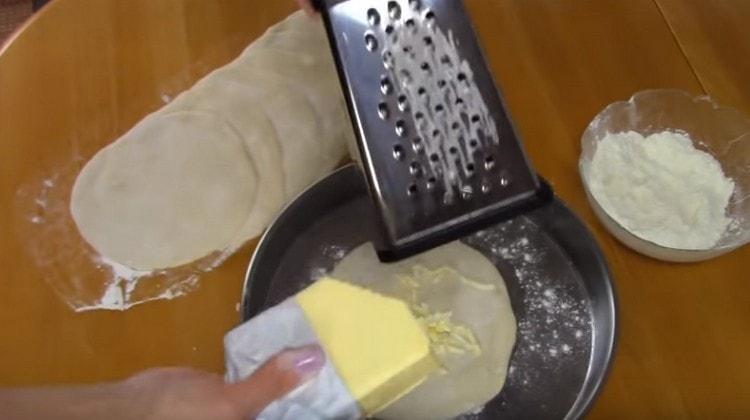 Für jede Teigrunde reiben wir kalte Butter.
