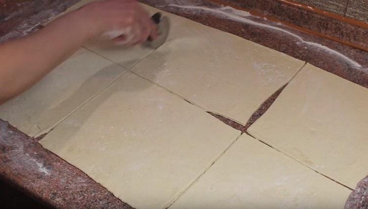 Tagliamo uno strato di pasta in quadrati uguali.