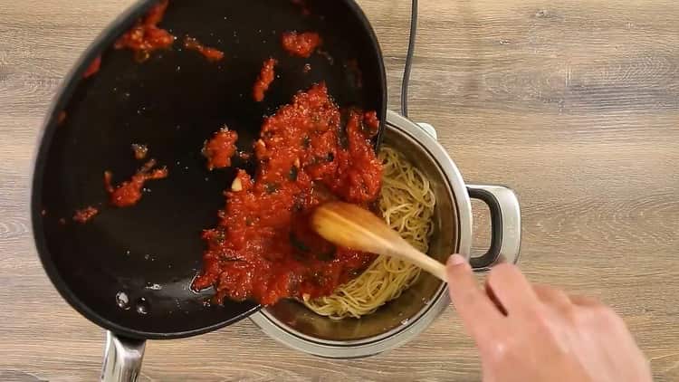 Fügen Sie Soße hinzu, um Spaghetti mit Tomatenmark zu machen