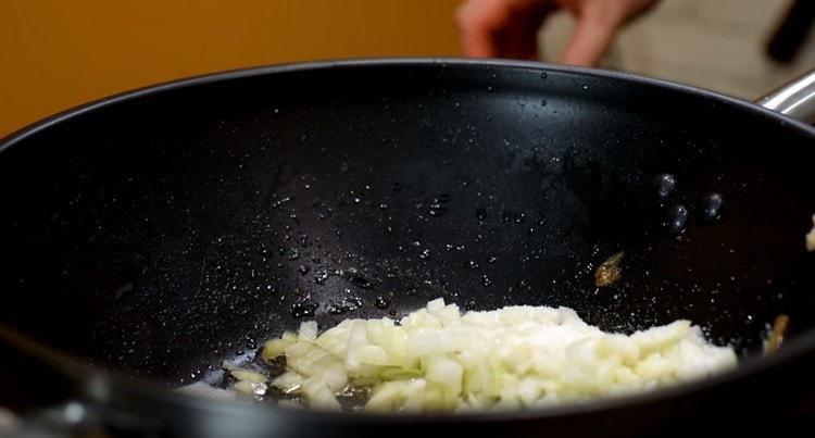 A szósz elkészítéséhez először vegye át a finoman apróra vágott zöldségeket a serpenyőbe.