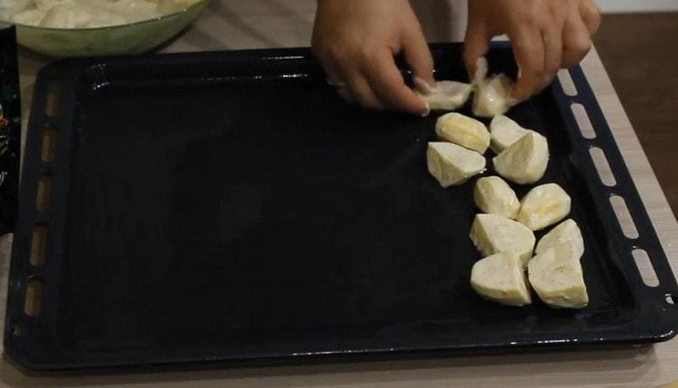 Ipinakalat namin ang mga patatas sa isang baking sheet na greased na may langis ng gulay.