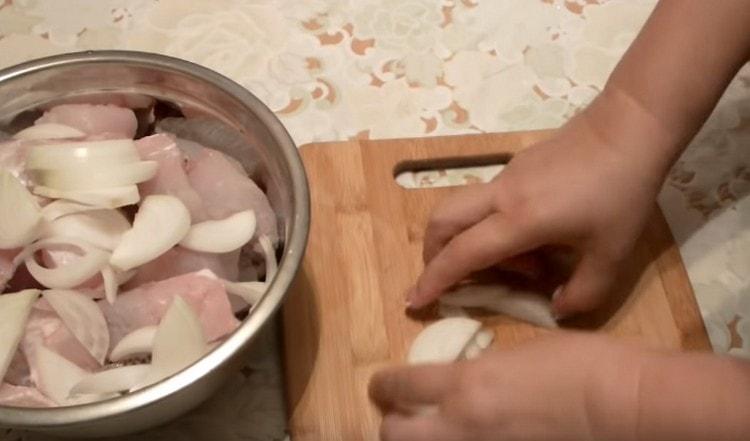 Die in halbe Ringe geschnittene Zwiebel zum Fisch geben.