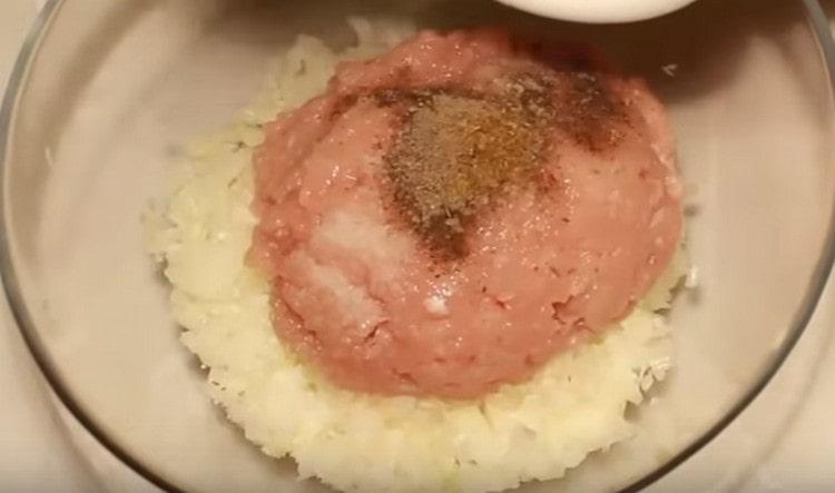 Aggiungi la cipolla tritata, il sale, il pepe, la zira alla carne macinata e mescola.