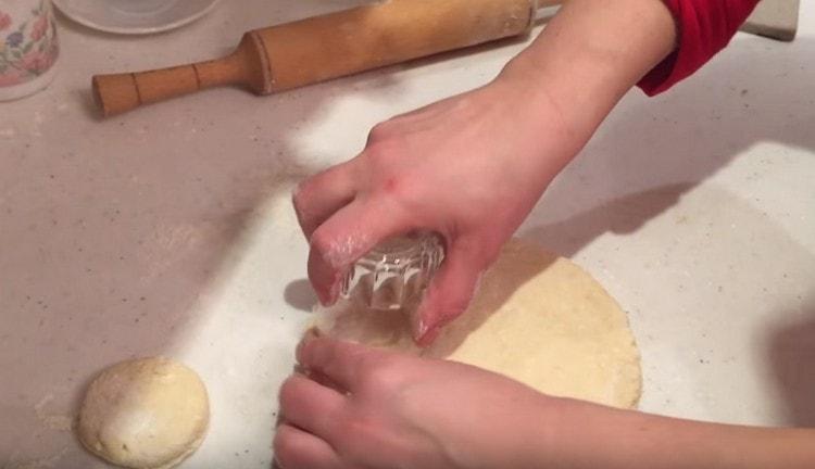 Изрежете кръгли парчета тесто с чаша.