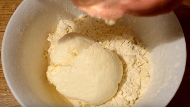 Fügen Sie Hüttenkäse der Butter und den Mehlkrumen hinzu.