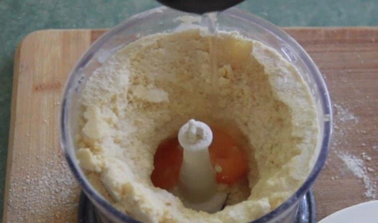 Į gautus trupinius įpilkite kiaušinio trynio, ledinio vandens ir druskos.