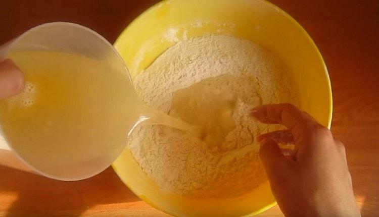 Ang isang halo ng mga sangkap na likido ay ibinuhos sa sifted flour.