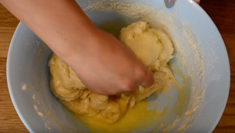 Разбъркайте маслото в тестото, добавете още брашно.
