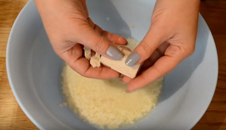 Versare il latte acido leggermente riscaldato in una ciotola e schiacciarlo con il lievito.