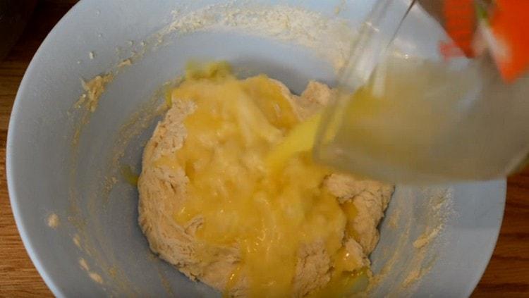 Když je těsto shromážděno v ještě lepivé hrudce, přidejte rozpuštěné máslo.