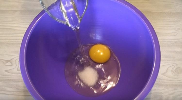 Į kiaušinį įpilkite augalinio aliejaus ir druskos.