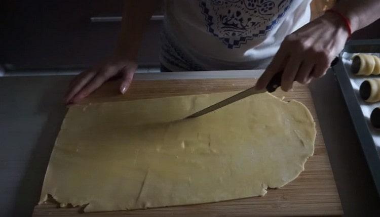 Stendere la pasta sottilmente e tagliarla a strisce lunghe.