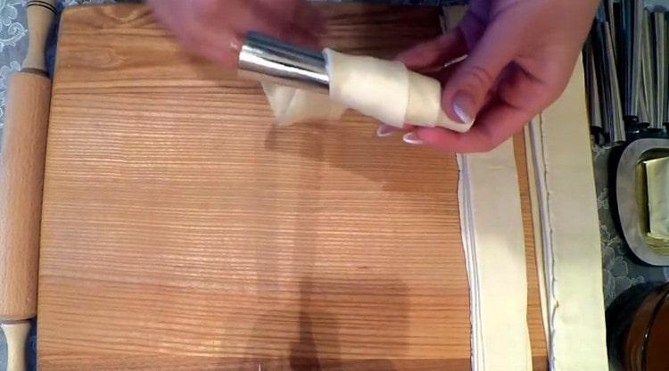 Τυλίξτε λωρίδες ζύμης γύρω από μεταλλικά καλούπια για σωλήνες.